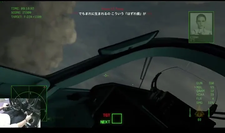 In-cockpit view over brown mountains with a green HUD, enemy target box, and a small picture-in-picture of the player's hands on a flight stick