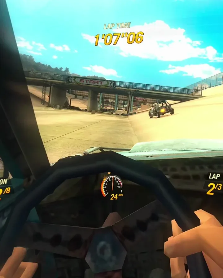 Cockpit view in FlatOut 2 VR: cartoon driver's hands grip a worn steering wheel, a 24 mph gauge on the dash, a "START" bridge and a rival car ahead under a blue sky