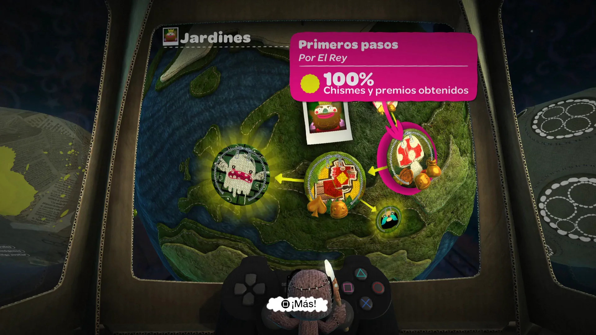 LittleBigPlanet level-select globe menu with Spanish UI labels and Sackboy holding a controller, from chasm's gameplay clip