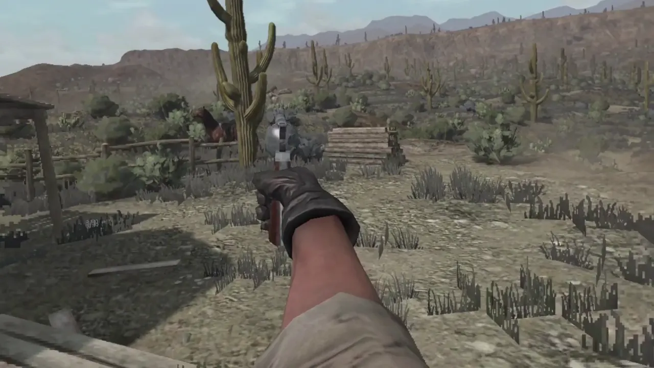 A black-gloved right hand aims a revolver toward a wooden fence and a tall saguaro cactus